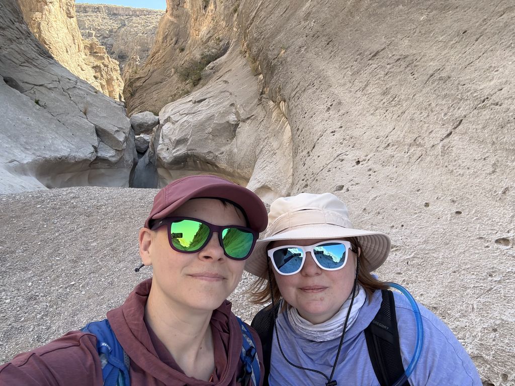 Us at the end of the trail, with a small balanced rock over a pool of water